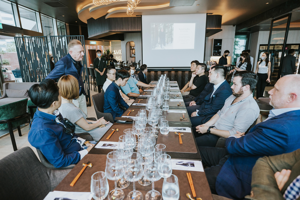 Guests seated along a long table for a corporate presentation at 1-Arden