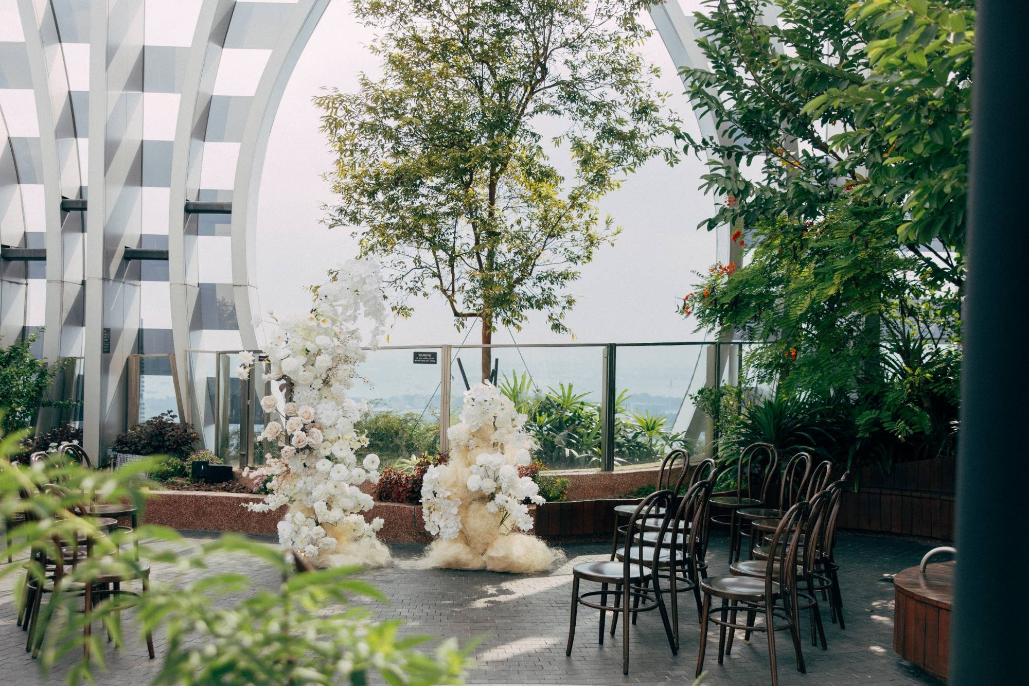 Sky garden solemnisation setup with white floral arrangements and seating at 1-Arden