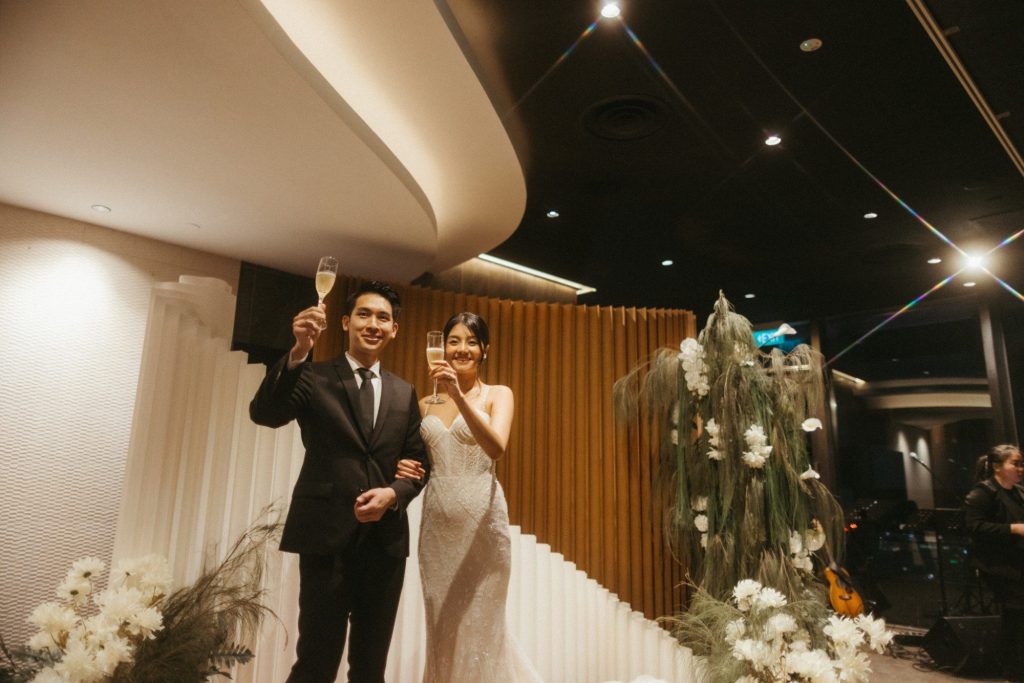 Newlyweds raising a champagne toast at their 1-Arden wedding reception